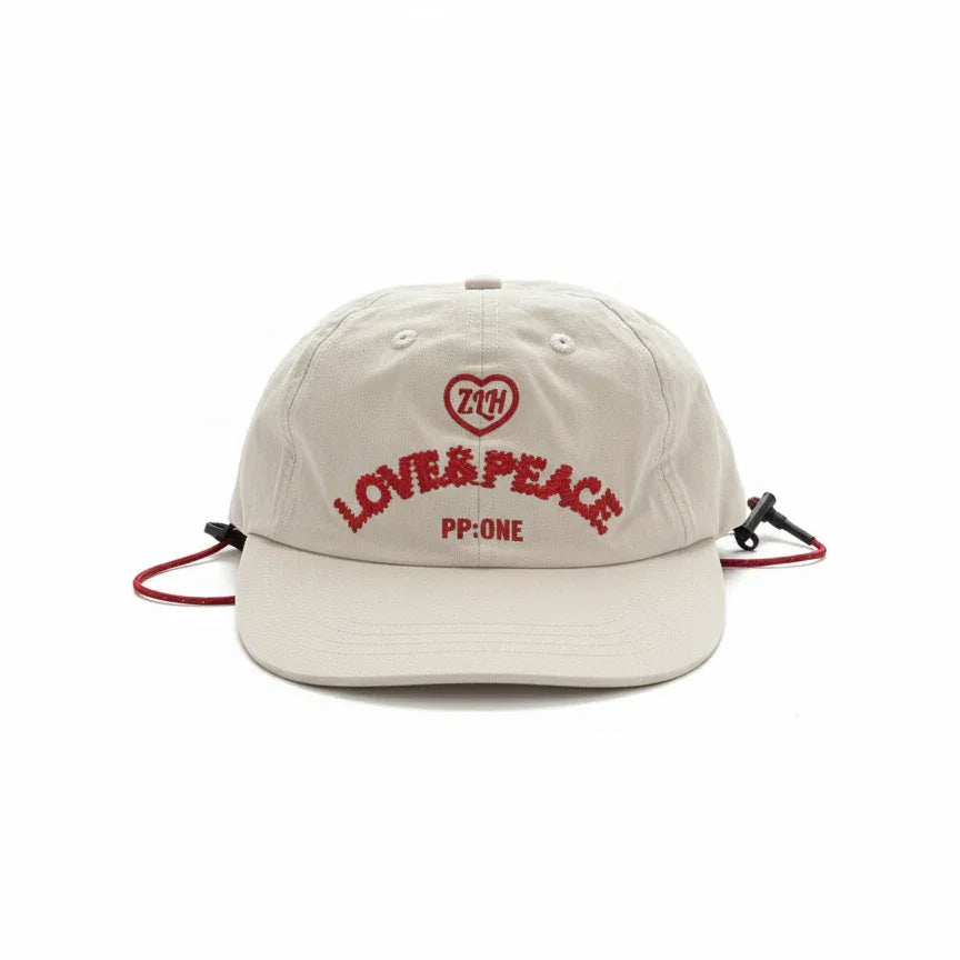 Beige cap with red 'LOVE & PEACE' embroidery, heart logo, and adjustable drawstring, PP:ONE design