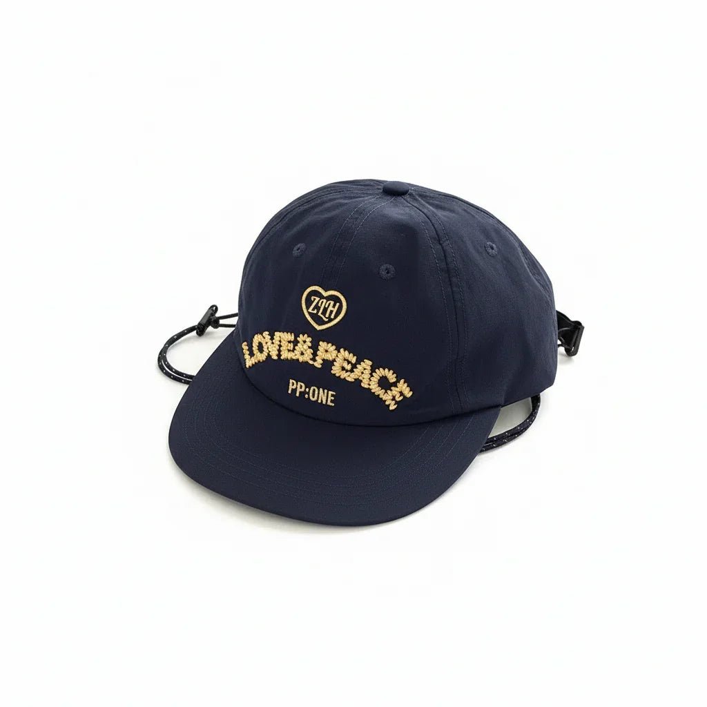 Navy blue cap with gold 'LOVE & PEACE' embroidery, heart logo, and PP:ONE text, adjustable strap design