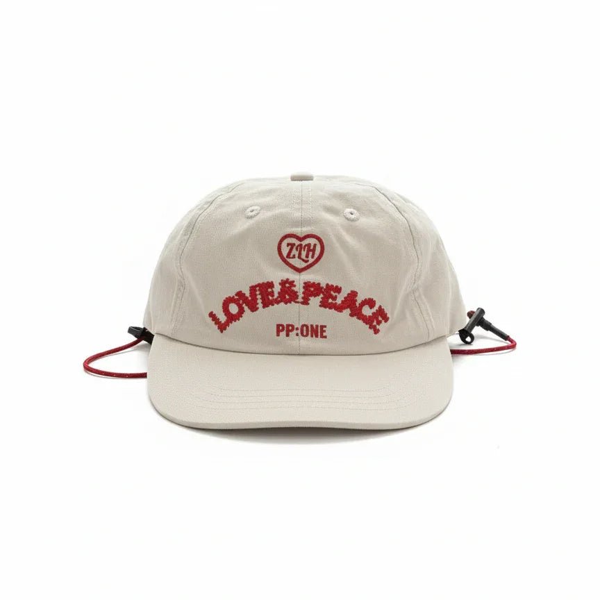 Beige cap with red 'LOVE & PEACE' embroidery, heart logo, and adjustable drawstring, PP:ONE design